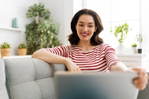 Young woman is chatting with a small business website using Live Chat to ask questions.