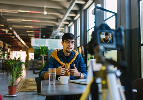 Young male small business owner in a video production about the products he sells at a retail store