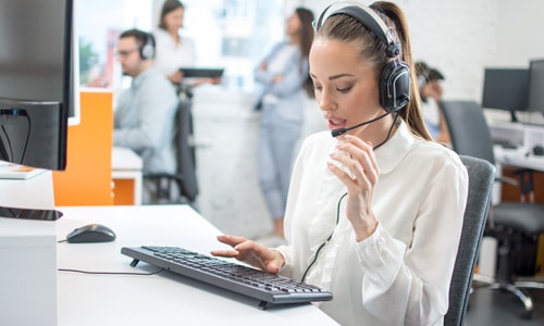 Technical support person with headset talking to small business owner about a website display issue