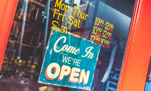 Glass door with hours and open sign for a business that was found online in a directory listing