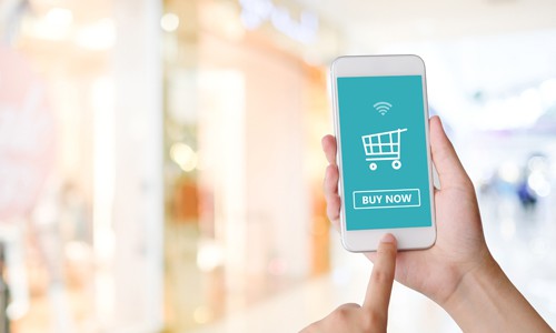 Hand holding smartphone with buy button to shop eCommerce website online instead of at retail store