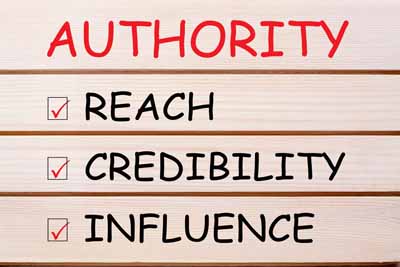 A wooden sign with the words authority, reach, credibility, and influence written on each plank