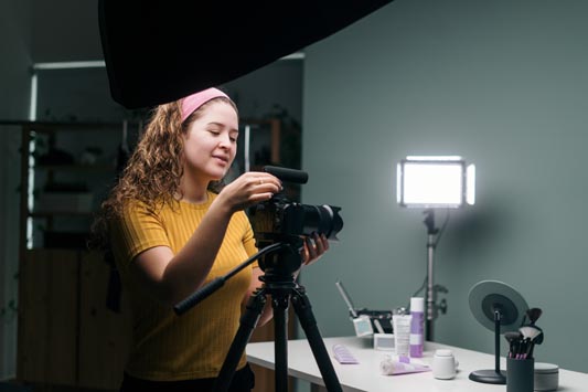 Behind the scenes video setup shows female operator adjusting camera prior to a product demo