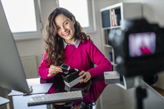 Female ecommerce owner making an unboxing video to showcase all the features of new smartwatches