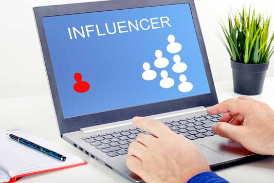 Social media influencer writing a blog with laptop to promote a small business on social media