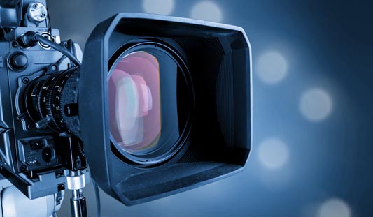 Close-up of a camera lens on blurred background of a video production studio