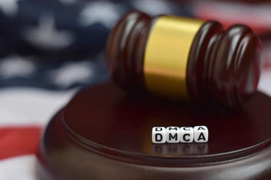 Close up of justice mallet with DMCA acronym spelled in blocks for Digital Millennium Copyright Act