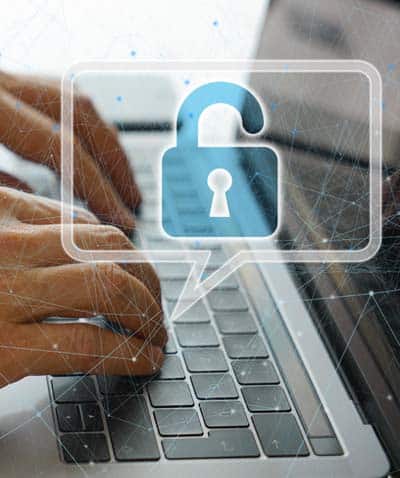 Close-up of hands typing on a laptop with graphic of a secure encrypted lock floating above hands