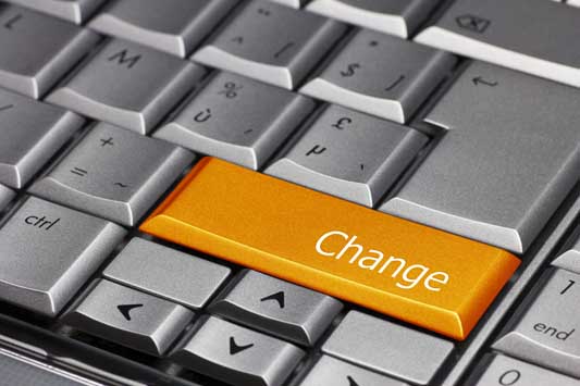 Close up of a gray computer keyboard that has a big orange button with the word change on it