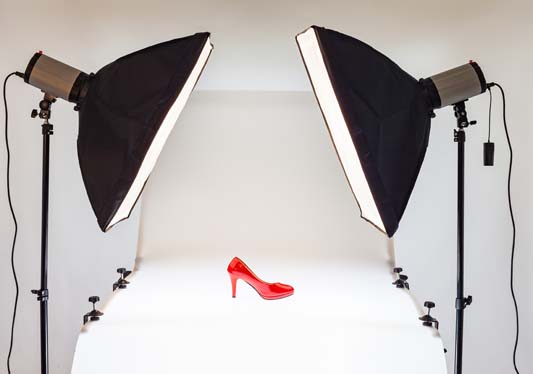 A red shoe on white background with two large lights pointing at shoe for crisp product photography