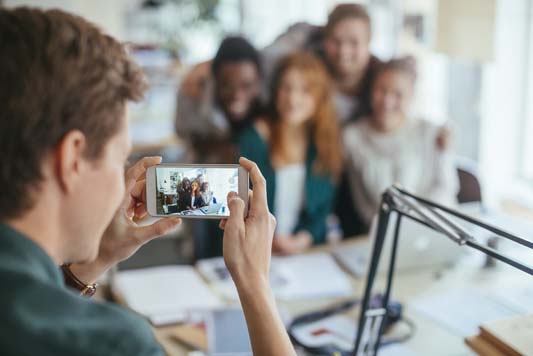 Close up of a group of employees posing for a picture that will get posted on social media