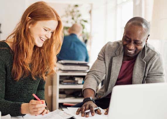 An SEO specialist working on Internet Marketing with a small business owner in an office